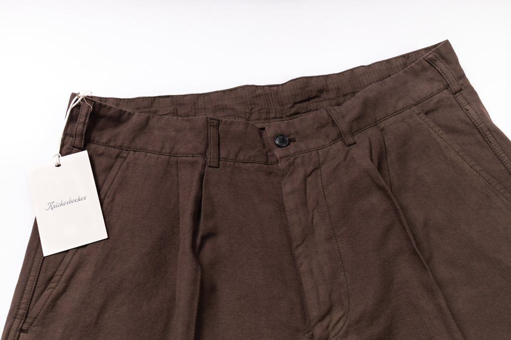 Brown pants with a tag on a white background