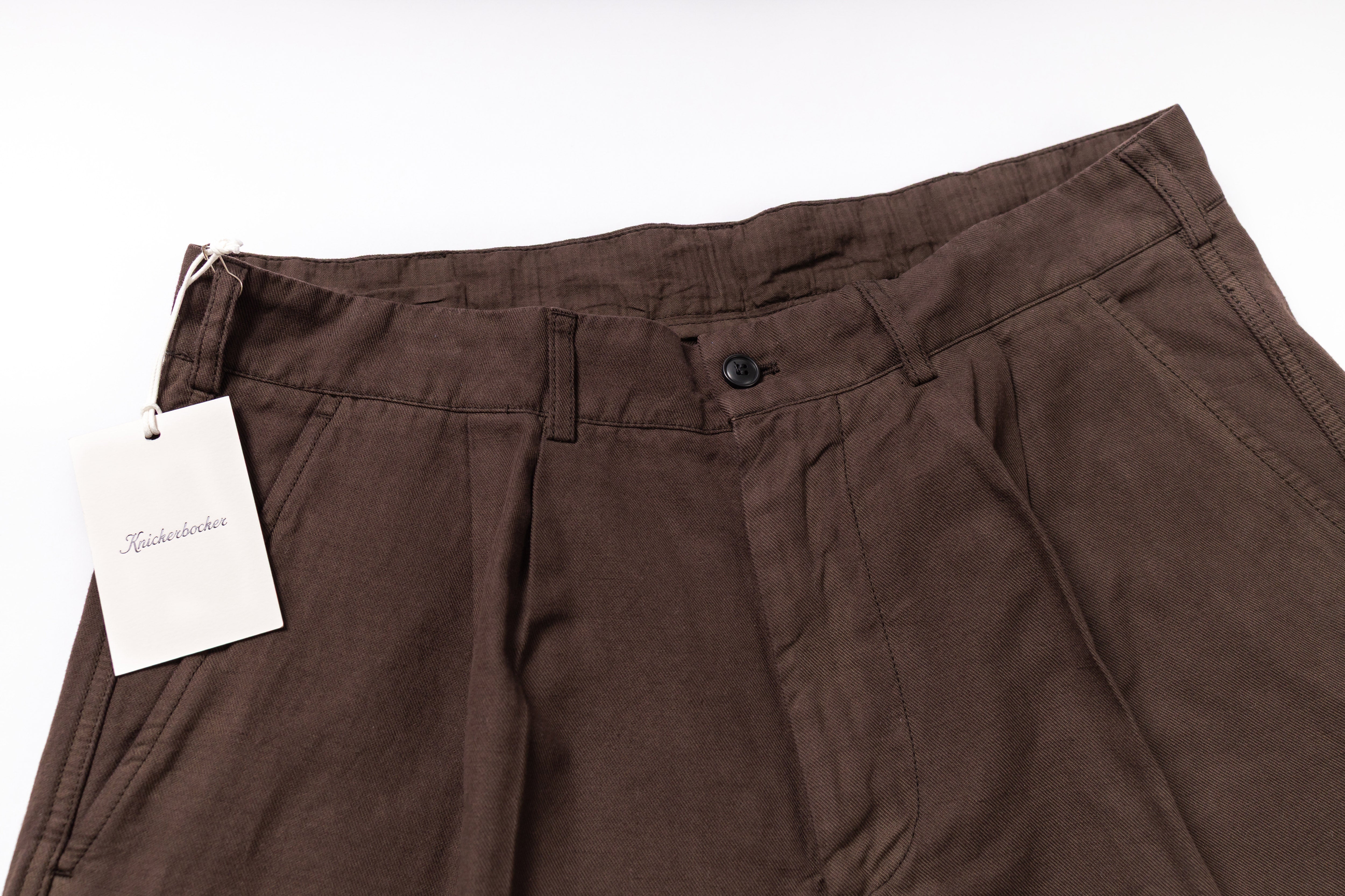 Brown pants with a tag on a white background