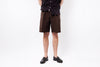 Person wearing brown shorts and black shoes on a white background