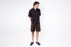 Man wearing a black shirt and brown shorts on a white background