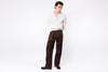 Man wearing a white shirt and brown pants on a white background