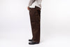 Person wearing brown pants and a light-colored shirt on a white background
