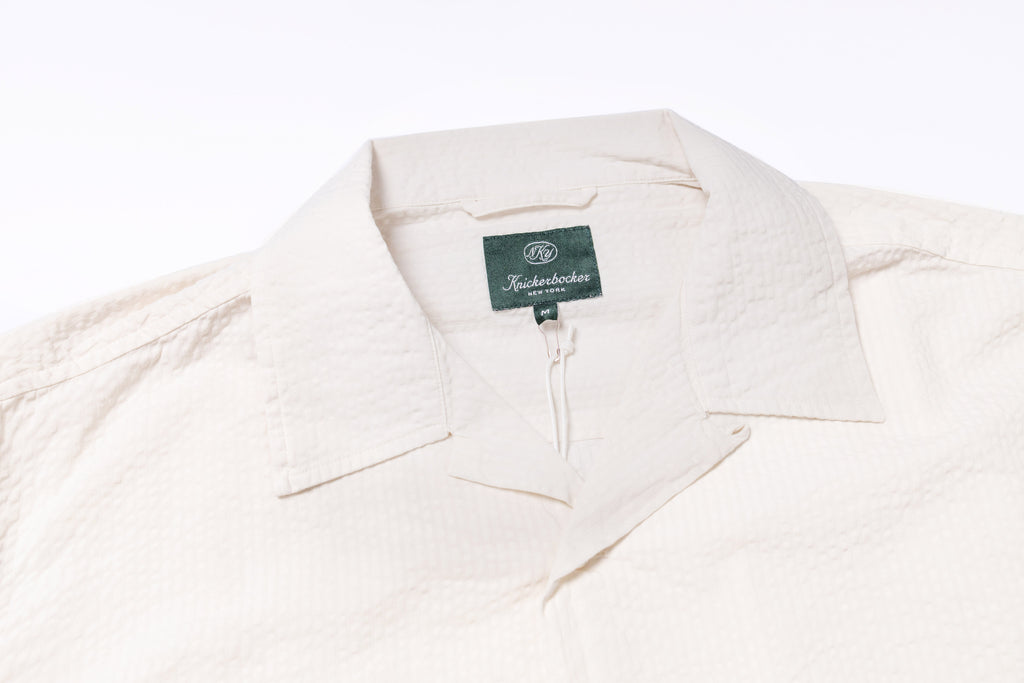 Close up of a collar of a white seersucker shirt
