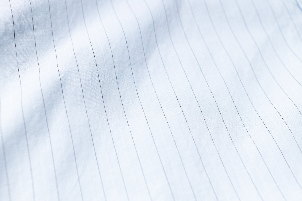 Close-up of a white shirt with horizontal pleats