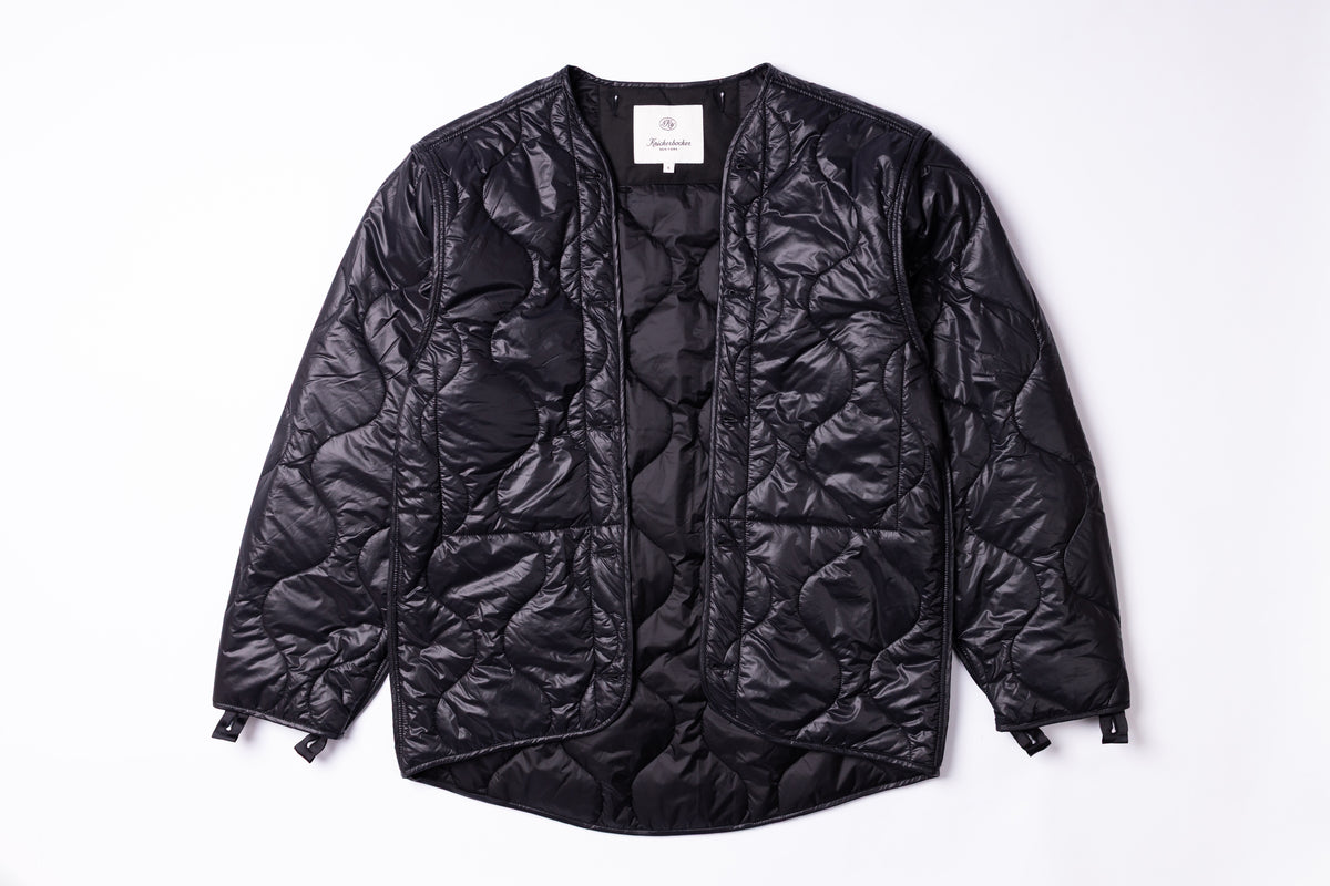 A black quilted puffer jacket with a crinkled, textured finish, laid flat against a clean white background.