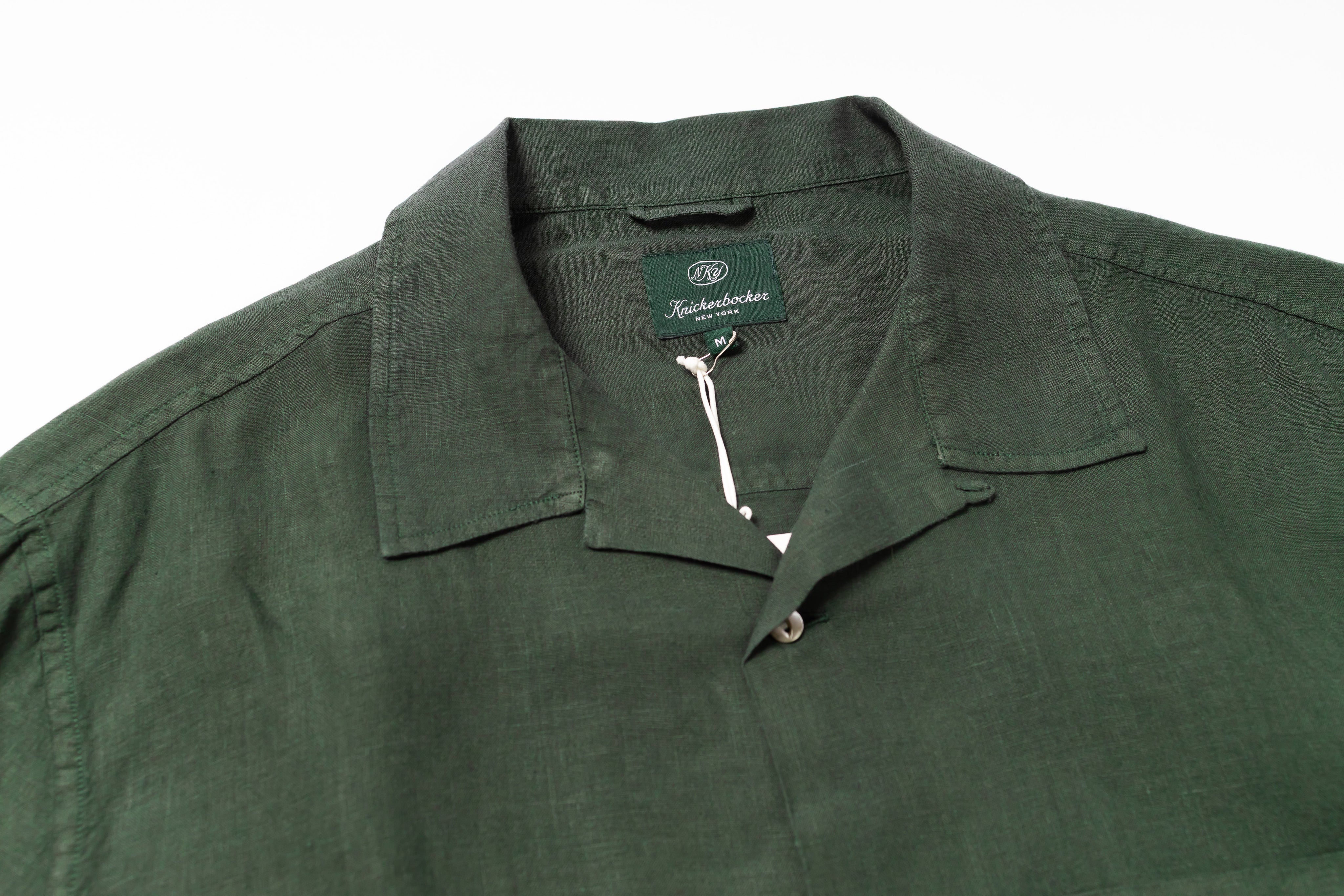 Close up on a green linen shirt on a white background