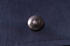 Close-up of a button with 'NKY' on a dark fabric background