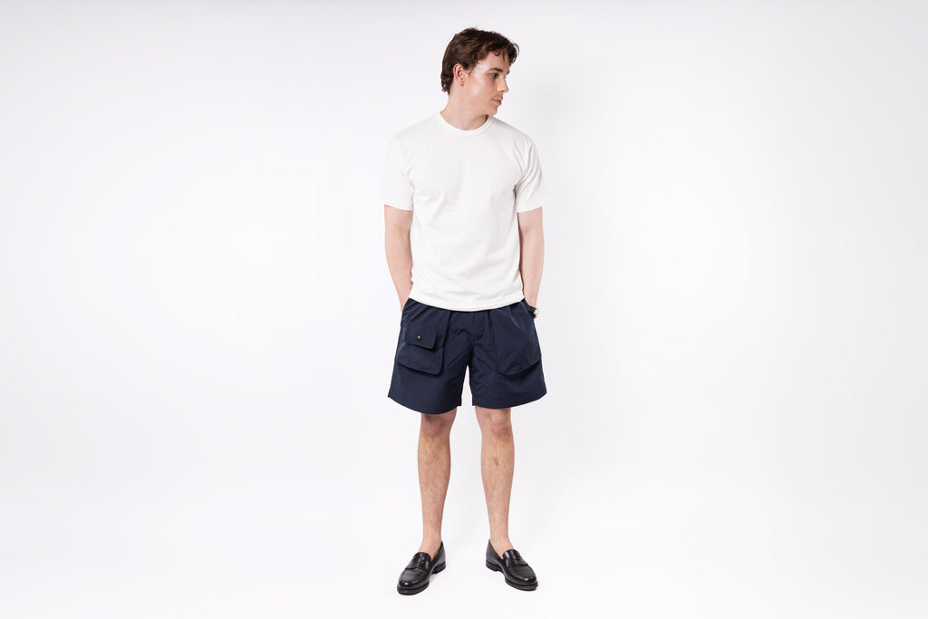 Person wearing a white t-shirt and navy shorts on a white background