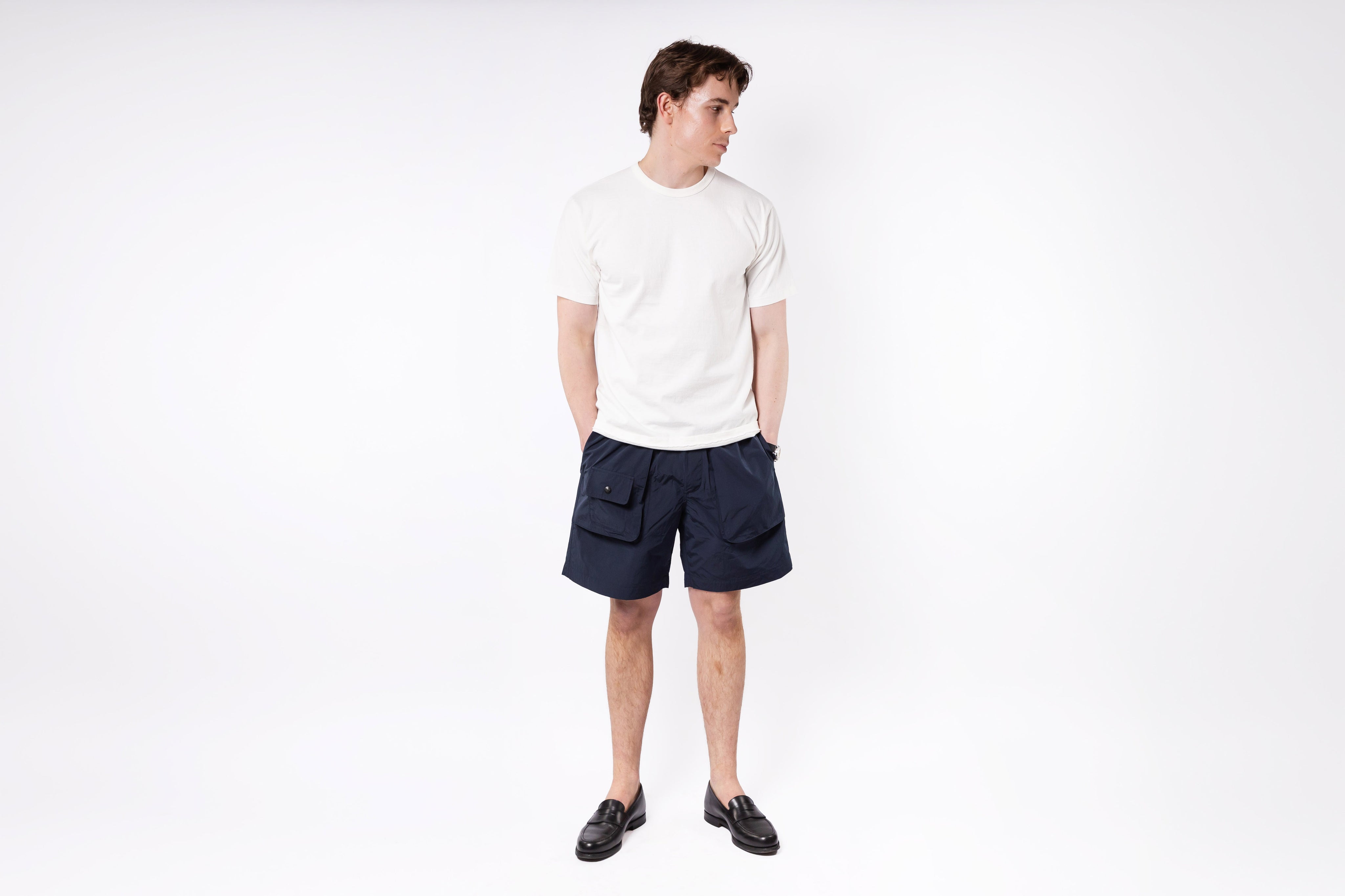 Person wearing a white t-shirt and navy shorts on a white background