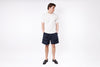 Person wearing a white t-shirt and navy shorts on a white background