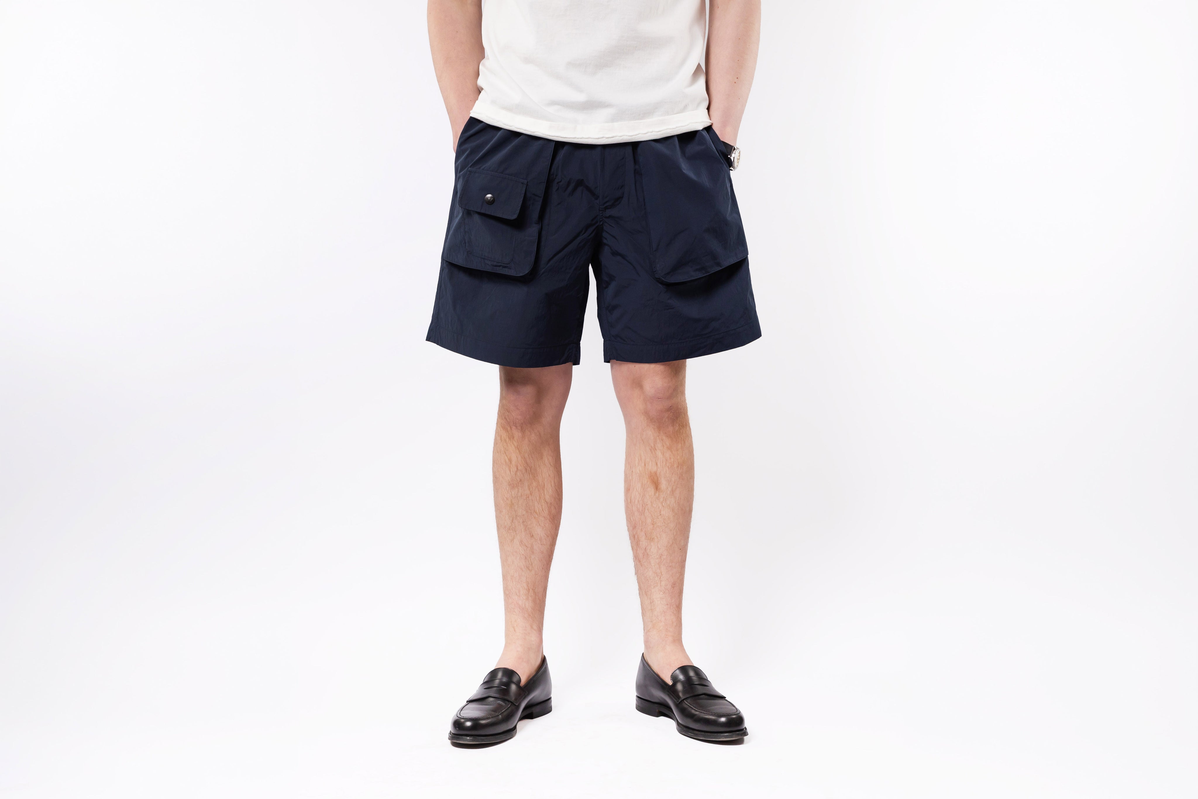 Person wearing navy shorts on a white background