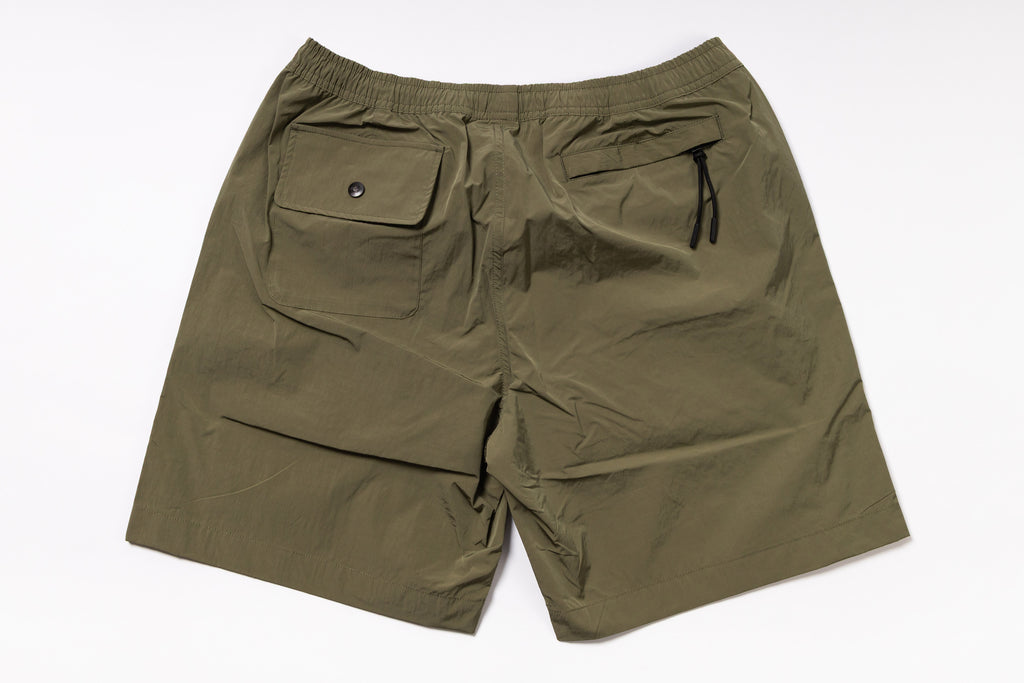 Olive green shorts with two front pockets on a white background