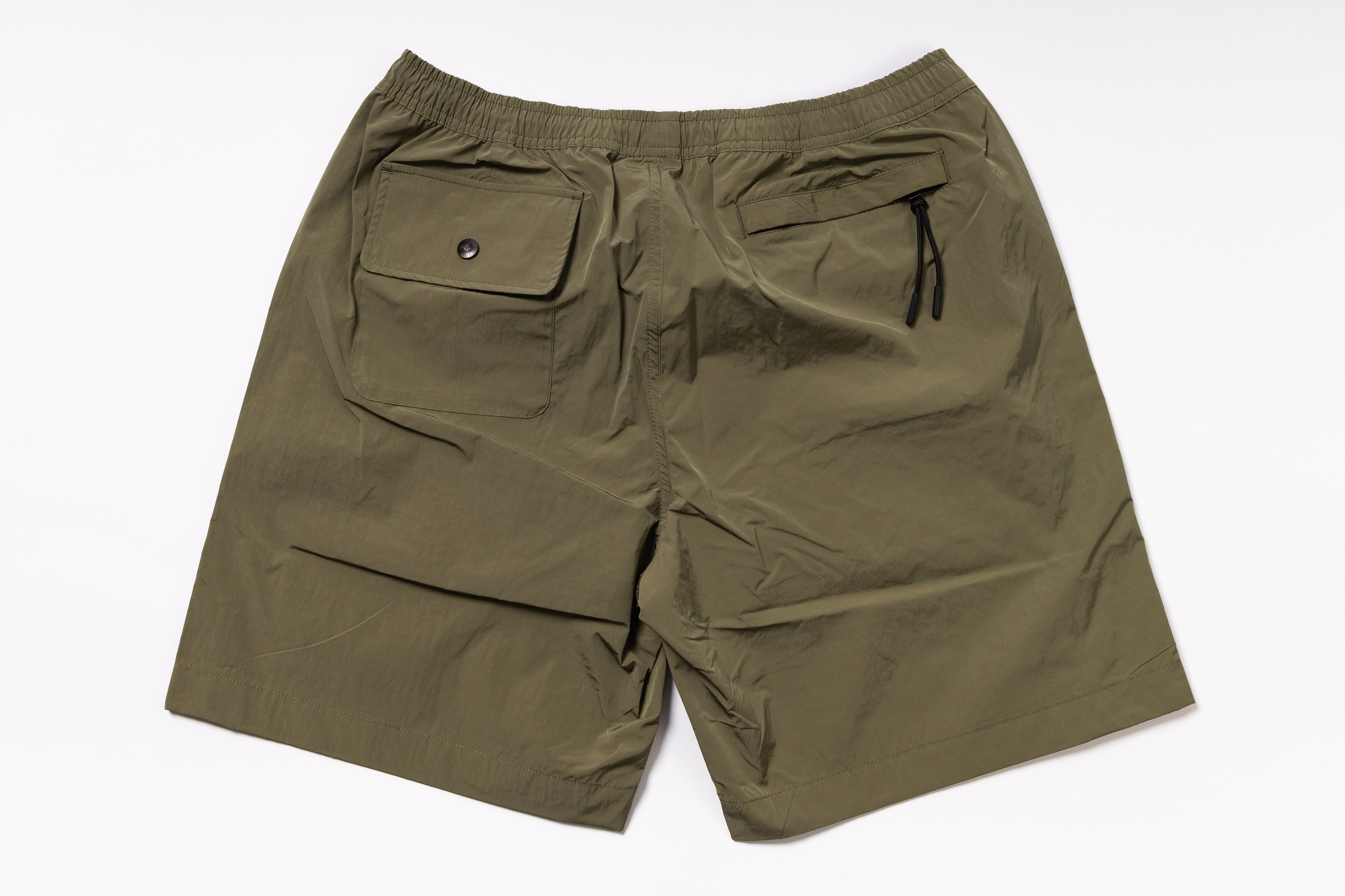 Olive green shorts with two front pockets on a white background
