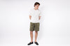 Person wearing a white t-shirt and green shorts on a white background