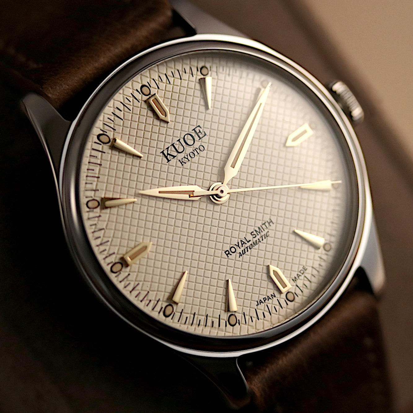 Close-up of a watch with a brown leather strap and detailed face.