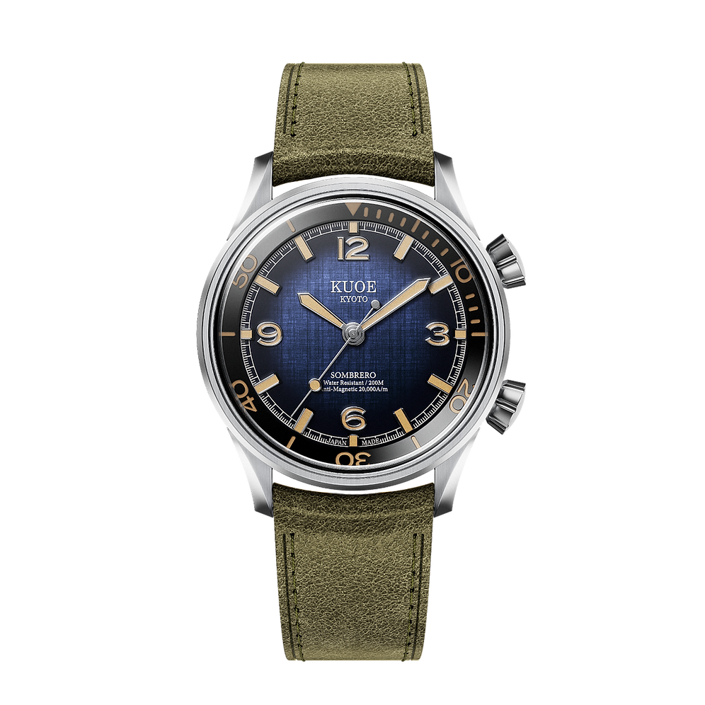 A Kuoe Kombero wristwatch featuring a silver stainless steel case, a blue textured dial with gold-tone markers, and an olive green textured strap, shown against a plain white background.