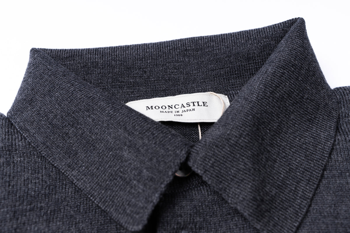 Close-up of a dark charcoal gray knit polo shirt collar with a white brand label reading MOONCASTLE.