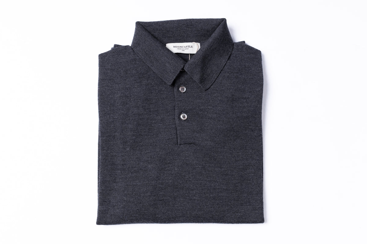 A folded dark charcoal gray polo shirt with a two-button placket, displayed flat against a solid white background.