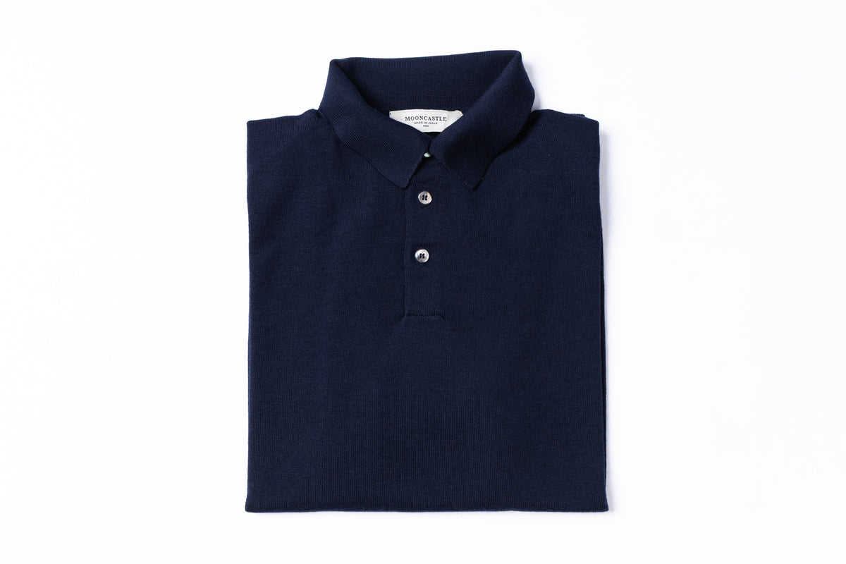 A folded dark navy blue polo shirt with a three-button placket, presented flat on a clean white background.