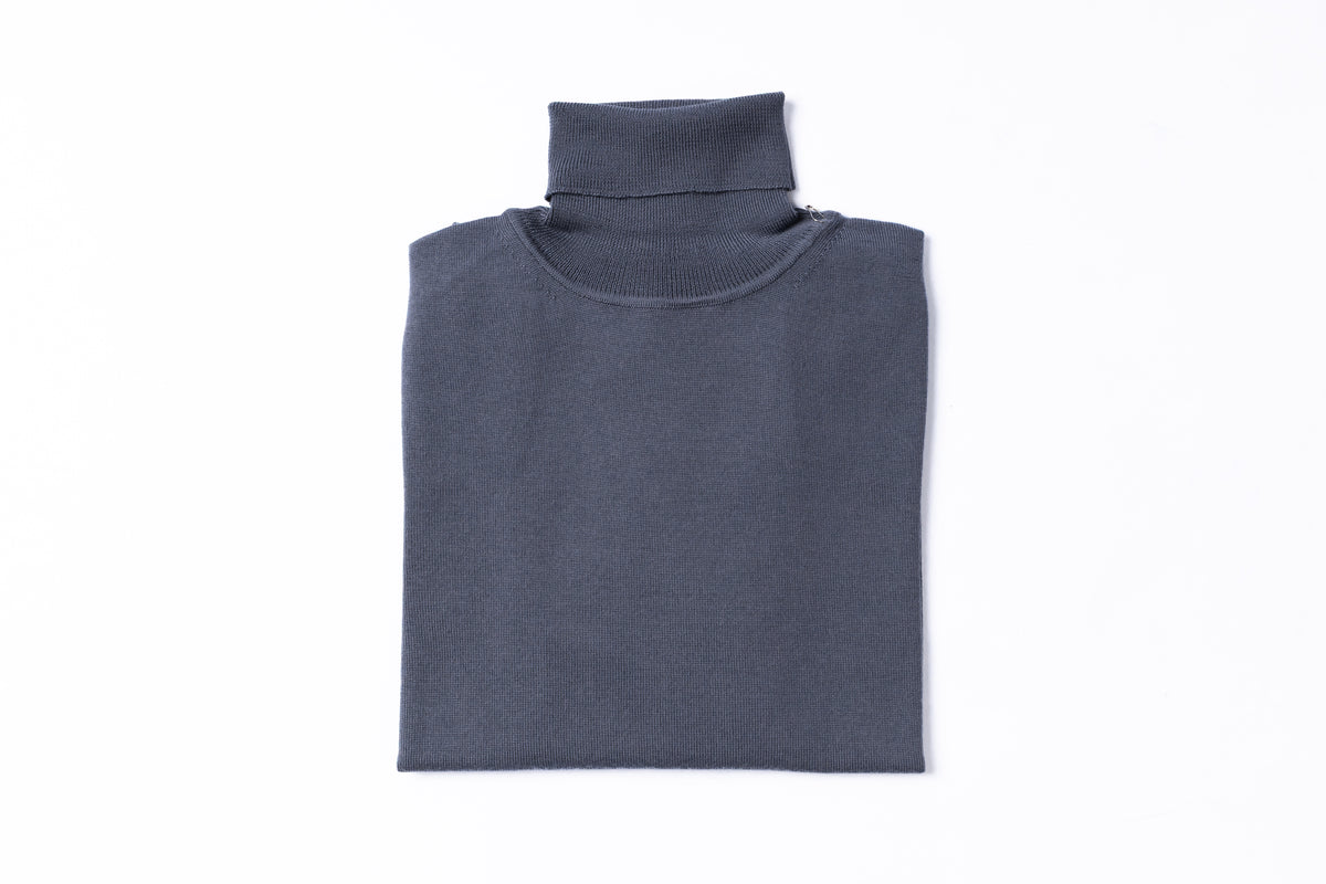 A folded dark gray ribbed knit turtleneck sweater on a solid white background.