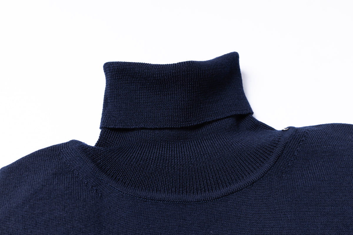 Close-up of a dark navy blue ribbed knit turtleneck sweater collar on a plain white background.