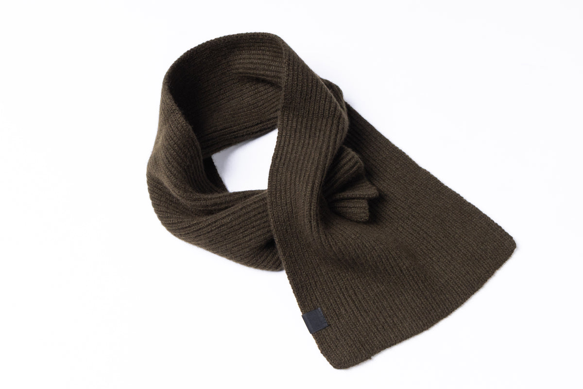A dark brown ribbed knit scarf, styled in a loop with a knot detail, shown on a plain white background.