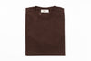 Folded brown sweater with a brand tag on a white background