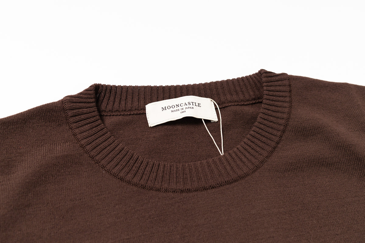 Brown sweater with a brand tag on a white background