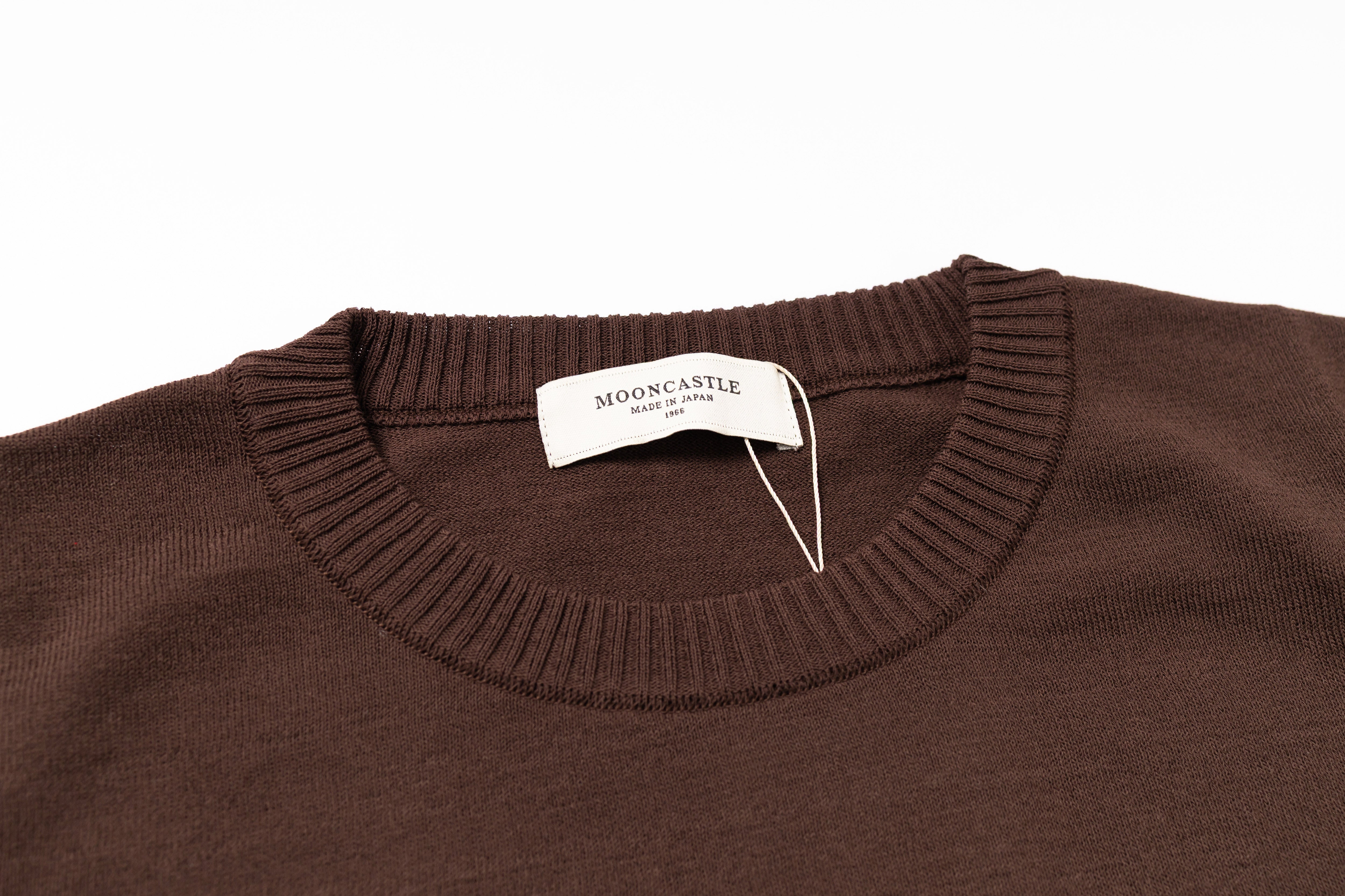 Brown sweater with a brand tag on a white background