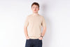 Person wearing a beige sweater and dark pants on a white background