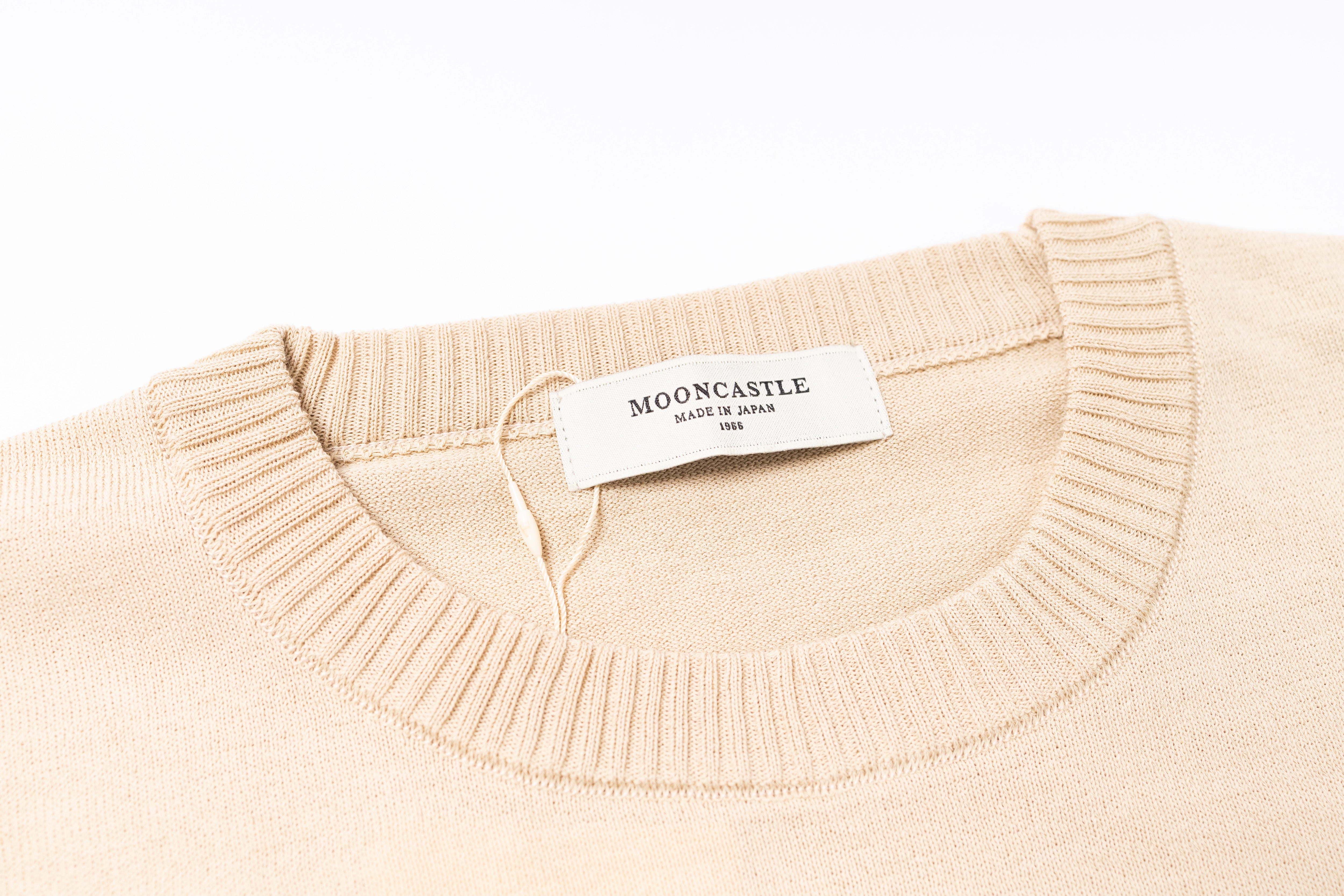 Beige sweater with a visible brand label on a white background