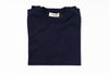 Folded navy blue sweater with a label on a white background