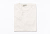 Folded white sweater with a brand label on a white background