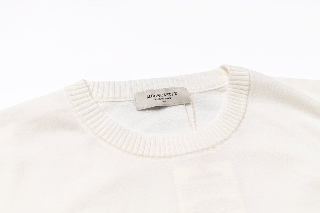 White sweater with a visible brand tag on a white background