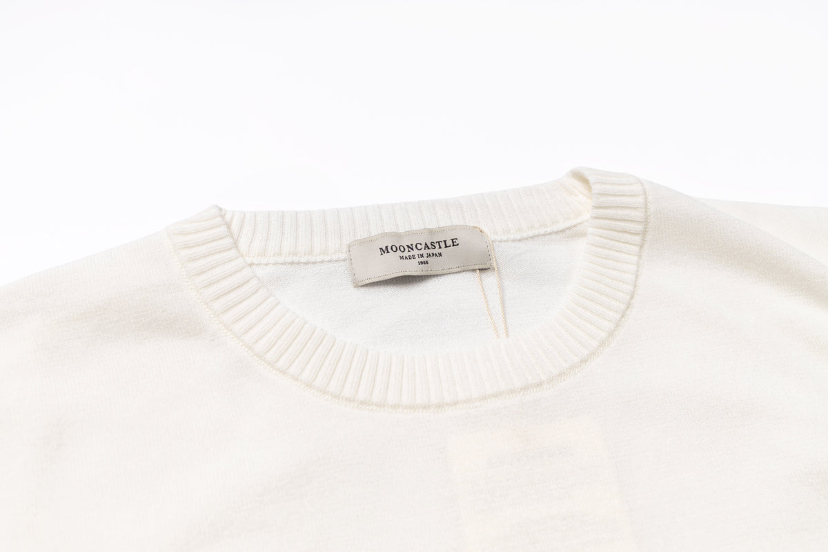 White sweater with a visible brand tag on a white background