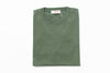 Folded green sweater on a white background