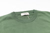 Green sweater with a brand tag on a white background
