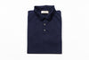 Folded navy blue polo shirt with a brand label on a white background