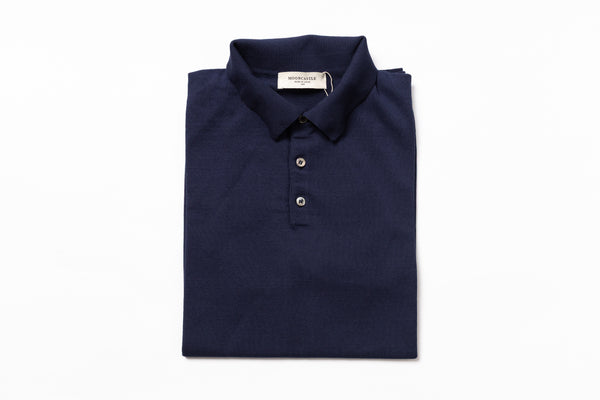 Folded navy blue polo shirt with a brand label on a white background