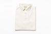 Folded cream-colored polo shirt on a white background