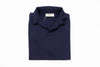 Folded navy blue polo shirt with a brand label on a white background