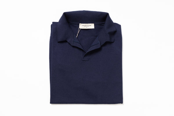 Folded navy blue polo shirt with a brand label on a white background