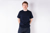 Person wearing a black t-shirt and dark jeans against a white background