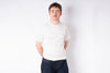 Person wearing a plain white t-shirt and dark pants on a white background