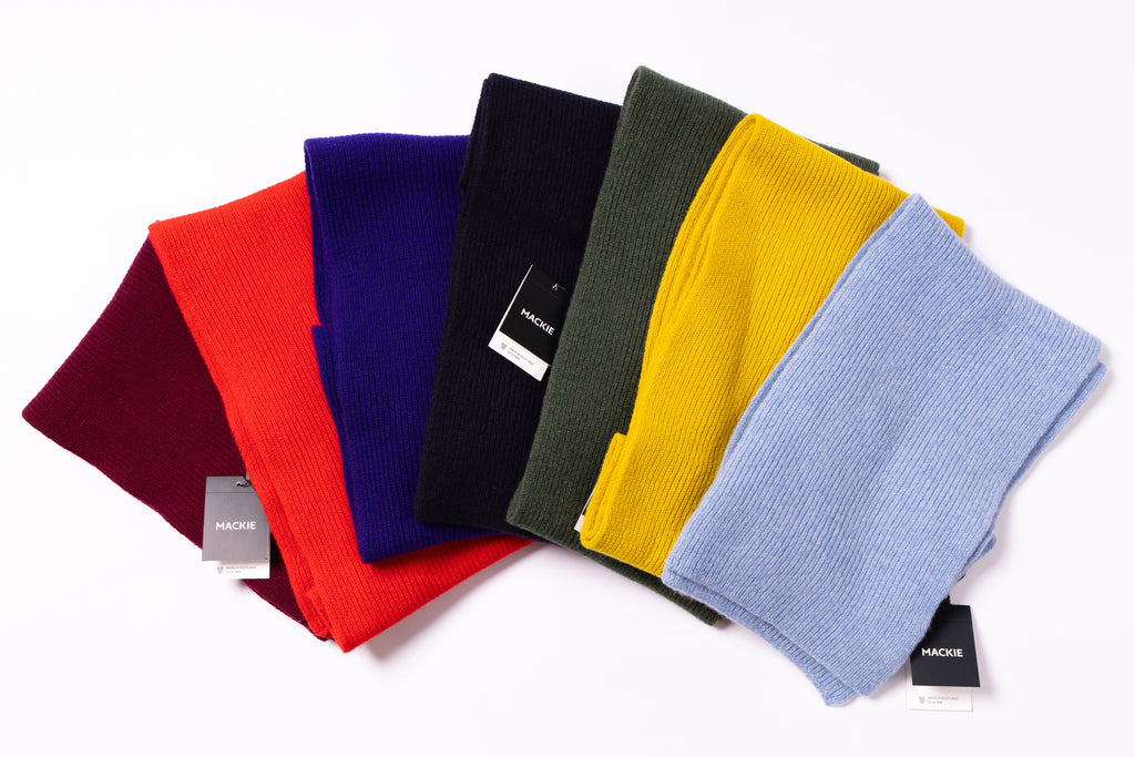 Set of colorful beanies arranged in a semi-circle on a white background