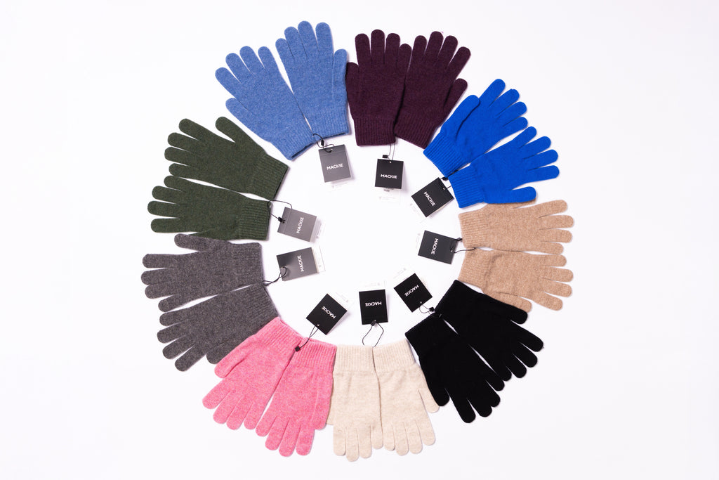 Circular arrangement of colorful gloves on a white background