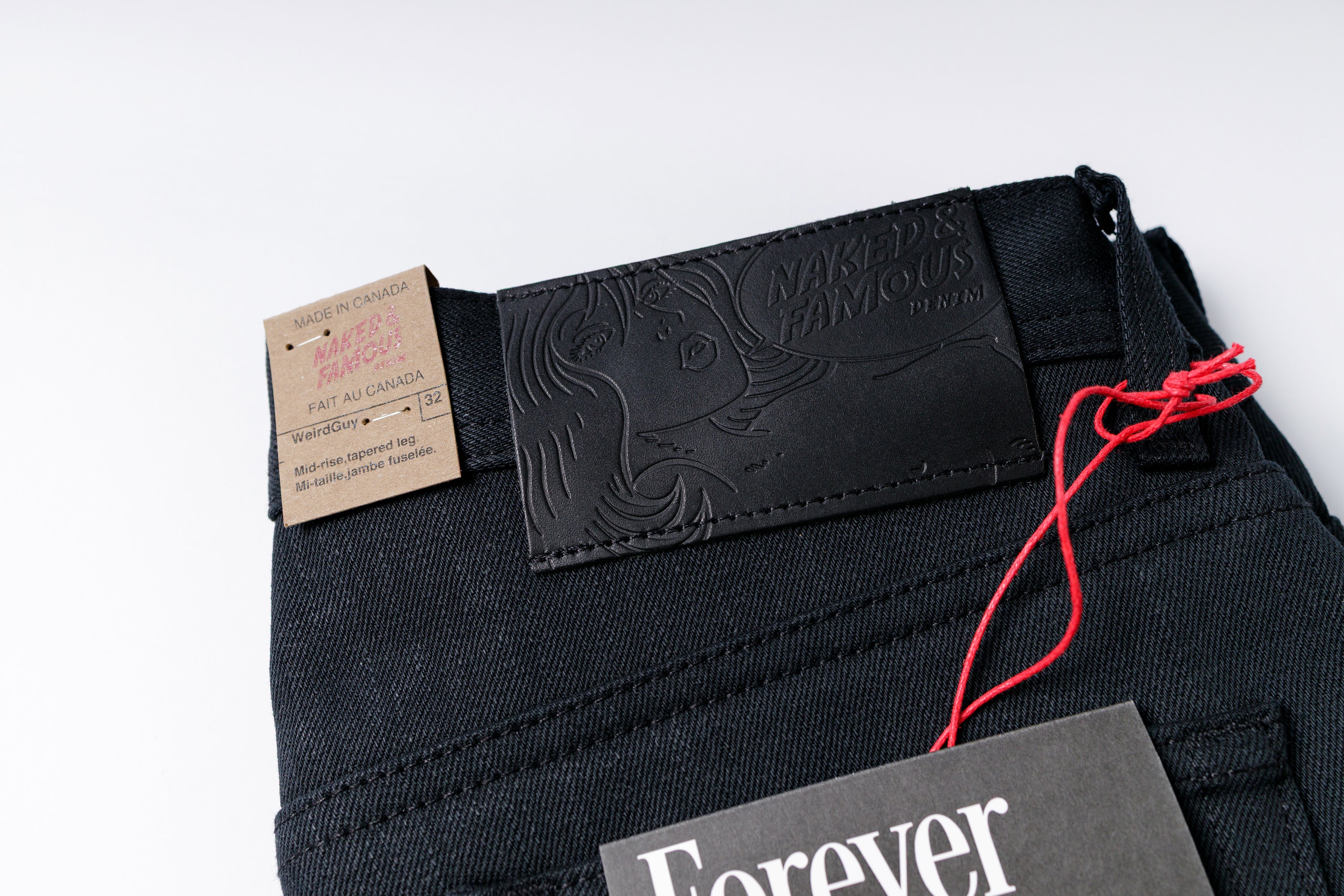 Black jeans with brand label on a white background