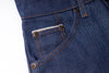 Close-up of blue denim jeans with stitching details on a white background