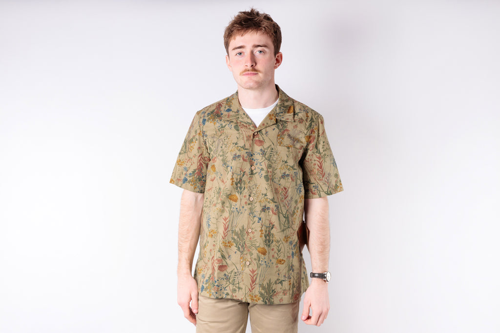 Man wearing a patterned shirt on a white background