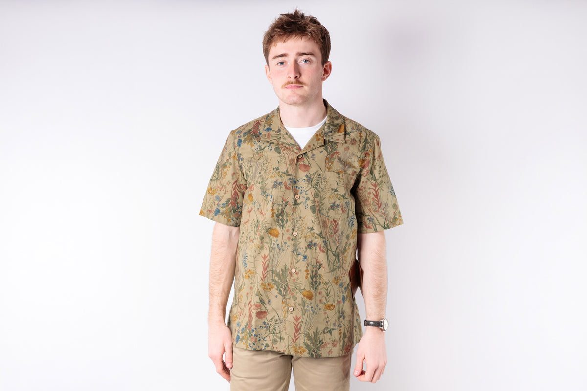 Man wearing a patterned shirt on a white background